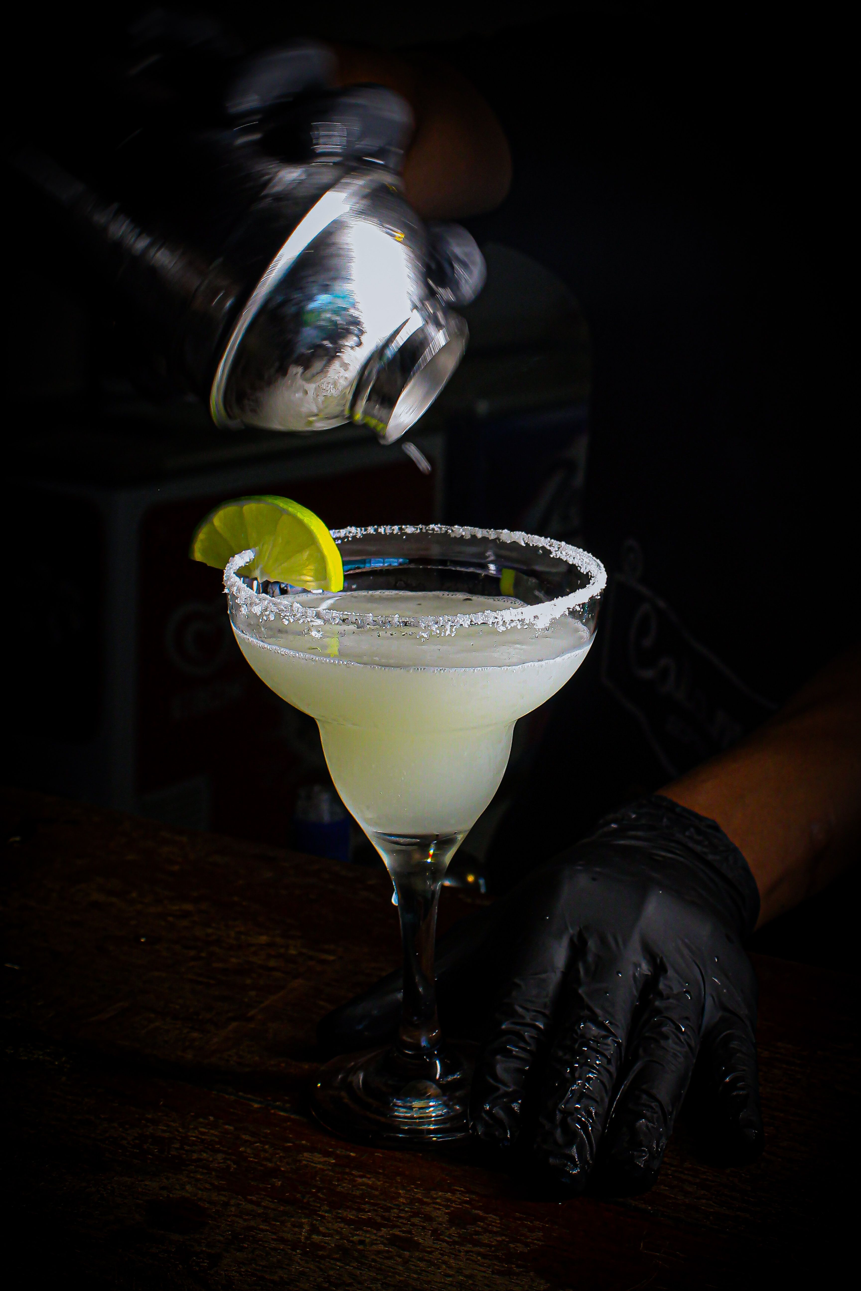 Bartender sirviendo margarita en barra